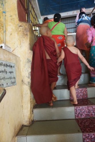 two young monks climbing up the steps to mt. Popa
